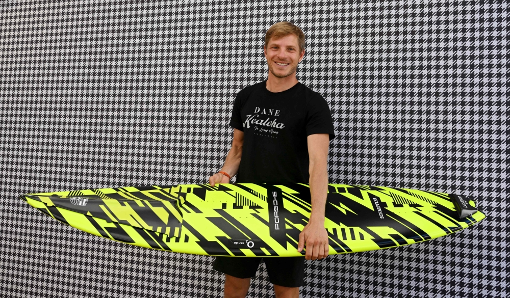 German surfer Sebastian Steudtner poses with his new board at the booth of German car producer Porsche of the IAA Automobile show in Munich, southern Germany, on September 8, 2023. Photo by Christof STACHE / AFP