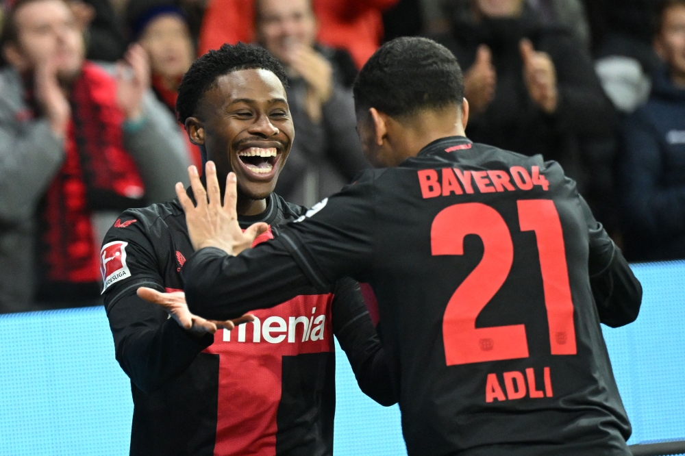 Bayer Leverkusen's English midfielder #19 Nathan Tella (L) celebrates scoring his team's fourth goal with Bayer Leverkusen's French forward #21 Amine Adli during the German first division Bundesliga football match Bayer 04 Leverkusen v 1 FC Union Berlin in Leverkusen, western Germany on November 12, 2023. (Photo by INA FASSBENDER / AFP) 
