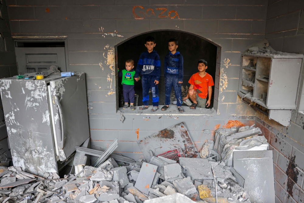 Children look on inside a damaged building following strikes on Rafah in the southern Gaza Strip on November 12, 2023. (Photo by Mohammed Abed / AFP)