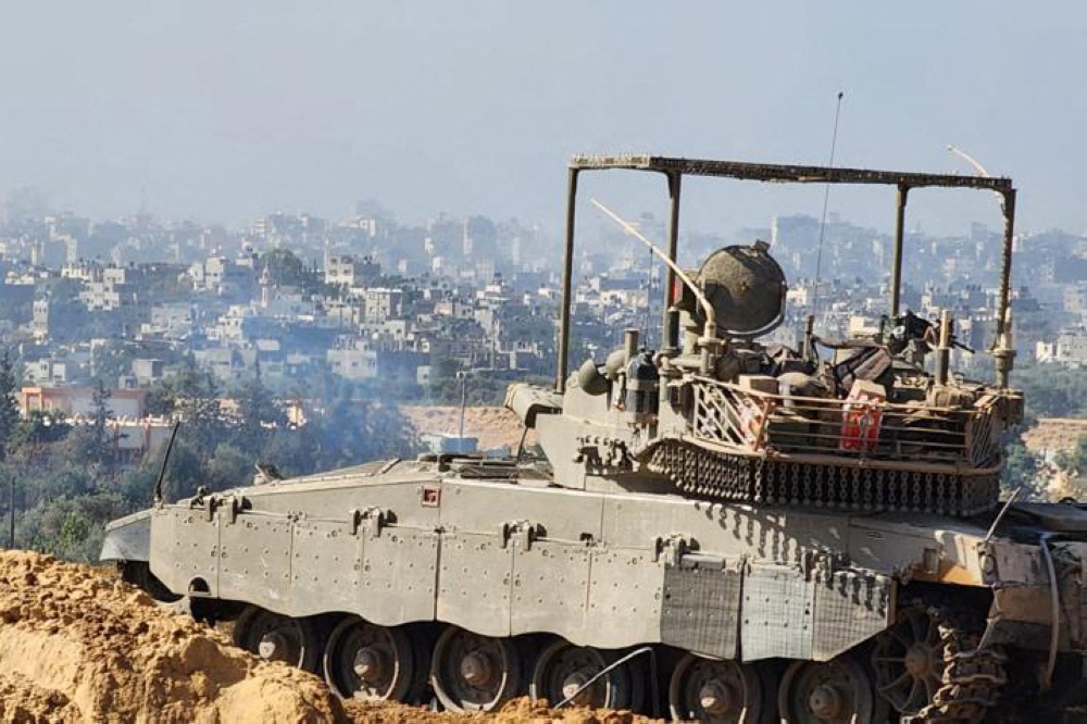 This handout picture released by the Israeli army on November 15, 2023, shows soldiers on an armed vehicle during a military operation around at Al-Shifa hospital in Gaza City. (AFP)