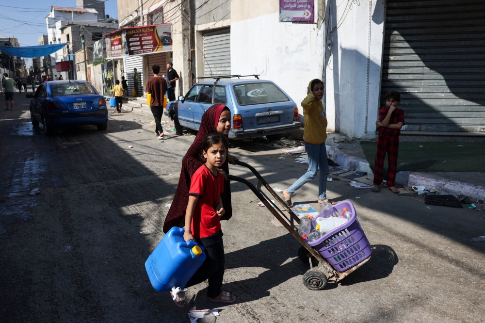 Palestinian children carry bottles, looking for water sources. (AFP file photo)
