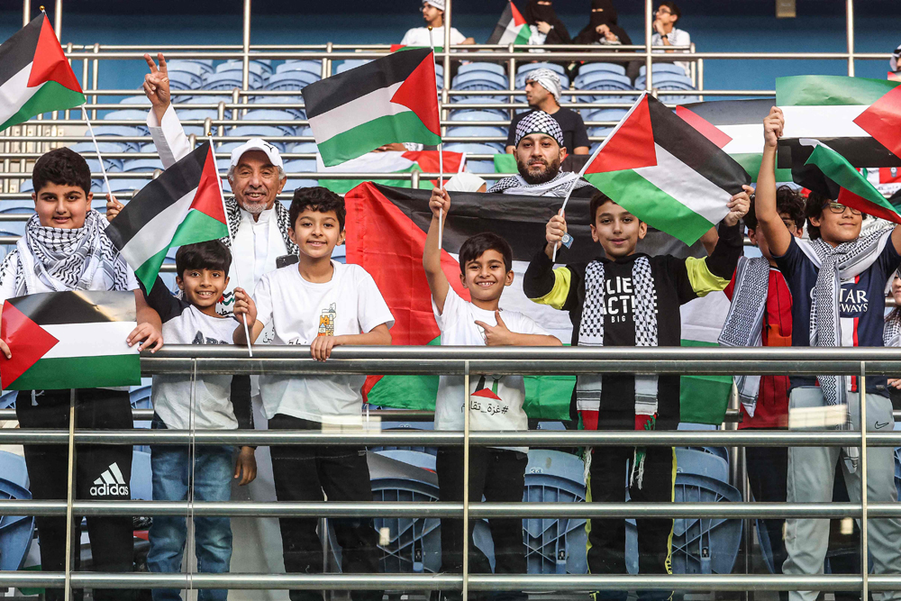 Supporters waving Palestinian flags pose for a picture prior to the 2026 FIFA World Cup AFC qualifier between Palestine and Australia. AFP
