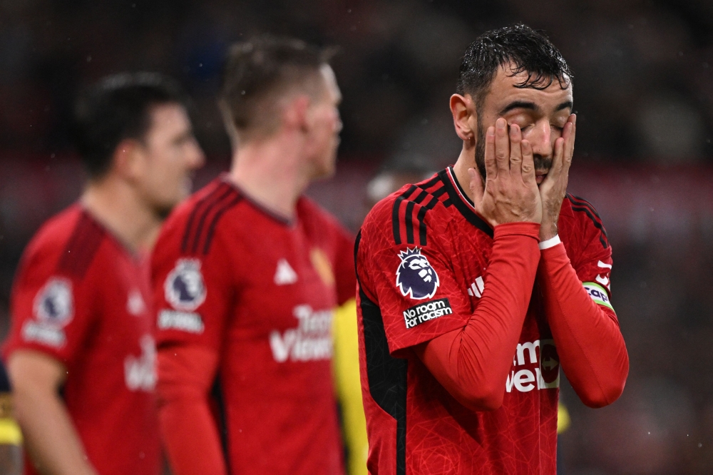 Manchester United's Portuguese midfielder #08 Bruno Fernandes (R) reacts during the English Premier League football match between Manchester United and Bournemouth at Old Trafford in Manchester, north west England, on December 9, 2023. (Photo by Oli SCARFF / AFP)