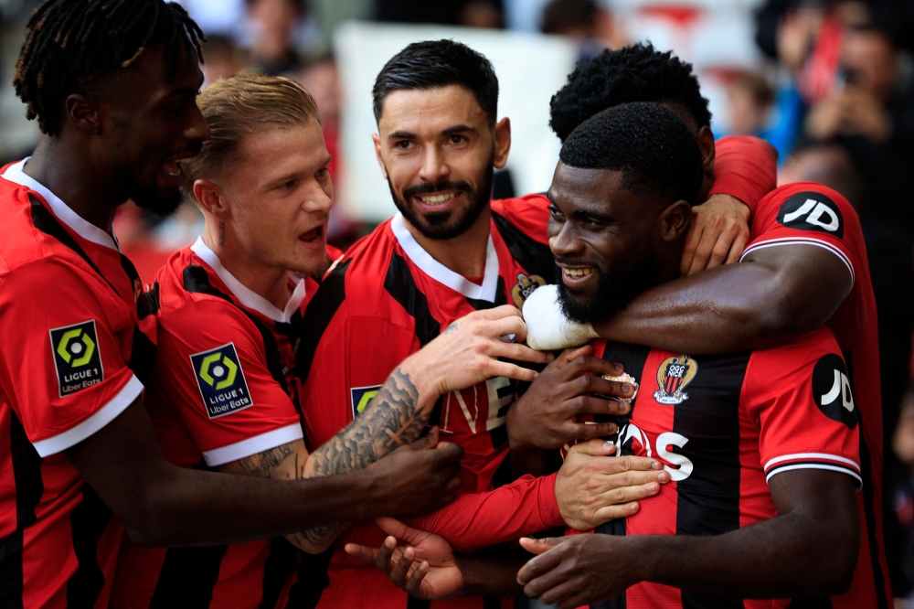 Nice's Ivorian forward #07 Jeremie Boga (R) celebrates with teammates after scoring his team's second goal during the French L1 football match between OGC Nice and Stade de Reims at the Allianz Riviera Stadium in Nice, south-eastern France, on December 10, 2023. (Photo by Valery HACHE / AFP)