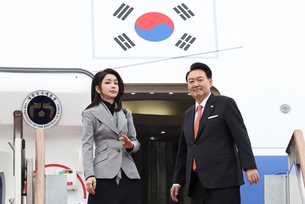 South Korea's President Yoon Suk Yeol (R) and his wife Kim Keon Hee (L) board their aircraft at Seoul Air Base in Seongnam on December 11, 2023, for a state visit to the Netherlands. Photo by YONHAP / AFP