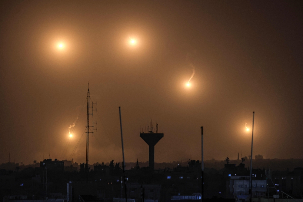Flares fired by Israeli soldiers over Khan Yunis in the southern Gaza Strip on December 22, 2023. (Photo by Mahmud Hams / AFP)