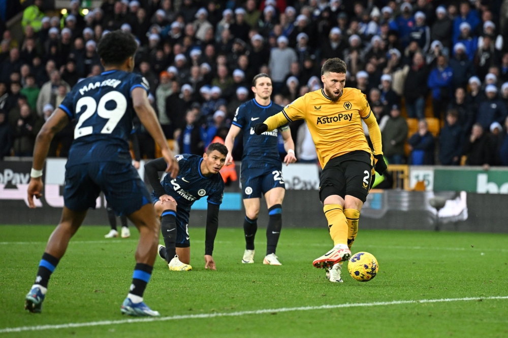 Wolverhampton Wanderers' Northern Irish defender #02 Matt Doherty (R) shoots and scores his team second goal during the English Premier League football match between Wolverhampton Wanderers and Chelsea at the Molineux stadium in Wolverhampton, central England on December 24, 2023. (Photo by Paul ELLIS / AFP)