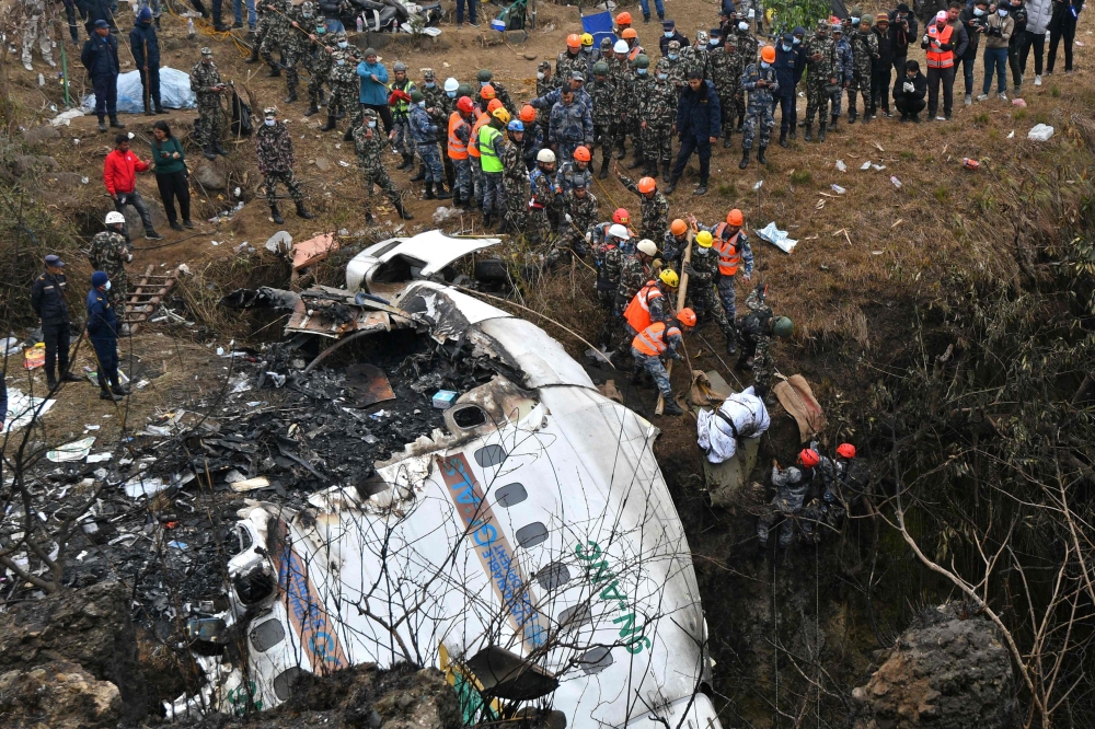 Rescuers pull the body of a victim who died in a Yeti Airlines plane crash in Pokhara on January 16, 2023. Photo by Prakash MATHEMA / AFP
