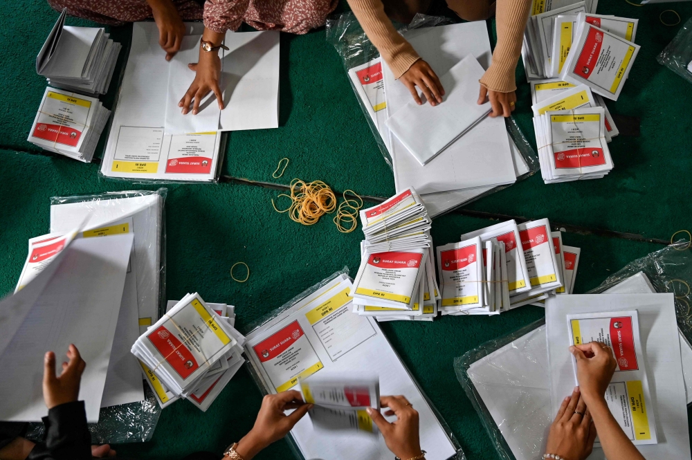 Workers prepare ballot papers in Banda Aceh on January 7, 2024, ahead of Indonesia's general election on February 14. (Photo by CHAIDEER MAHYUDDIN / AFP)
