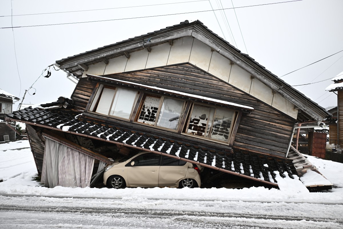 A damaged car lies underneath a collapsed building at Shika town in Hakui District, Ishikawa Prefecture on January 8, 2024 after a major 7.5 magnitude earthquake struck the Noto region on New Year's Day. (Photo by Philip FONG / AFP)