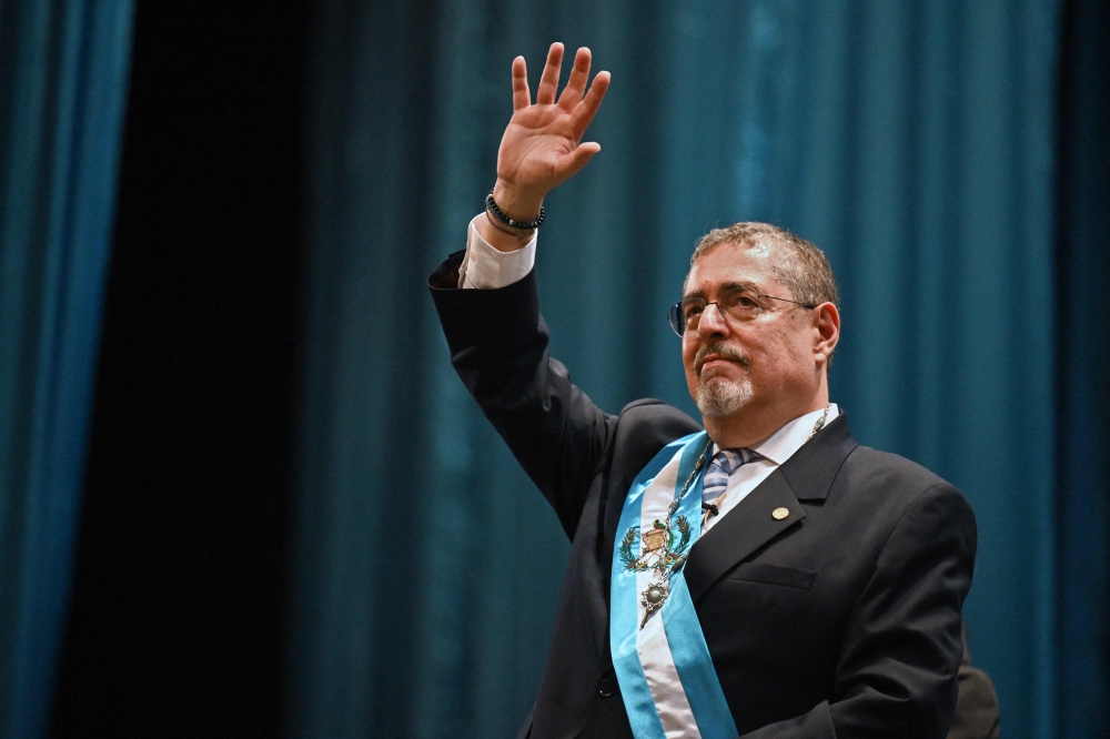 Guatemala's new President Bernardo Arevalo waves after swearing in during his inauguration ceremony at the Miguel Angel Asturias Cultural Centre in Guatemala City, early on January 15, 2024. (Photo by Johan ORDONEZ / AFP)
