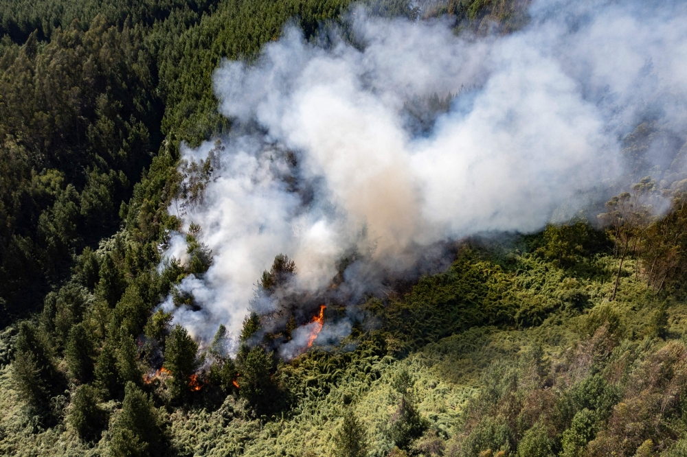 This aerial view shows smoke billowing from a forest fire in Nemocon, Colombia on January 24, 2024. (Photo by Luis Acosta / AFP)