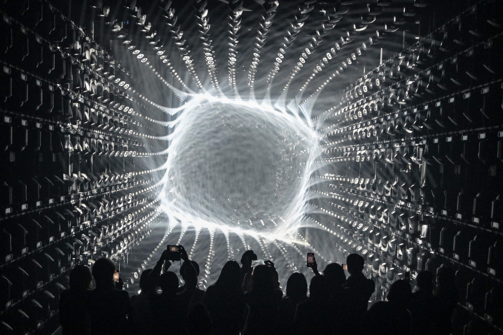 Visitors watch a light display during a tour of the new location for the digital art of Japanese collective 