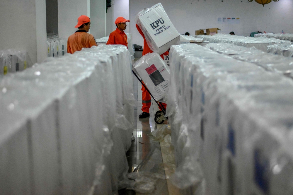 Officials transport ballot boxes for distribution to polling places in Jakarta on February 13 2024, ahead of the general elections. (Photo by BAY ISMOYO / AFP)
