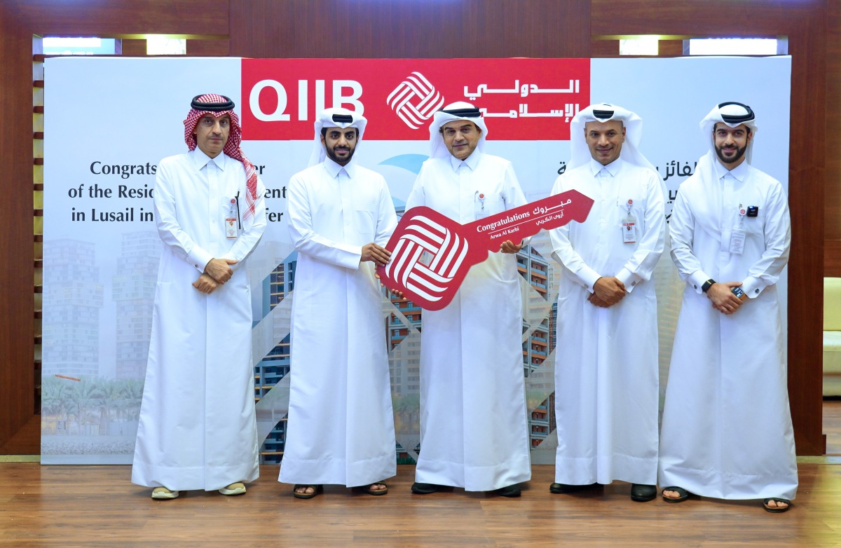 QIIB CEO, Dr Abdulbasit Ahmad Al Shaibei giving the key to the luxurious apartment at Seef Lusail to Qahtan Salem Al Karbi, brother of the winner Arwa Salem Al Karba.
