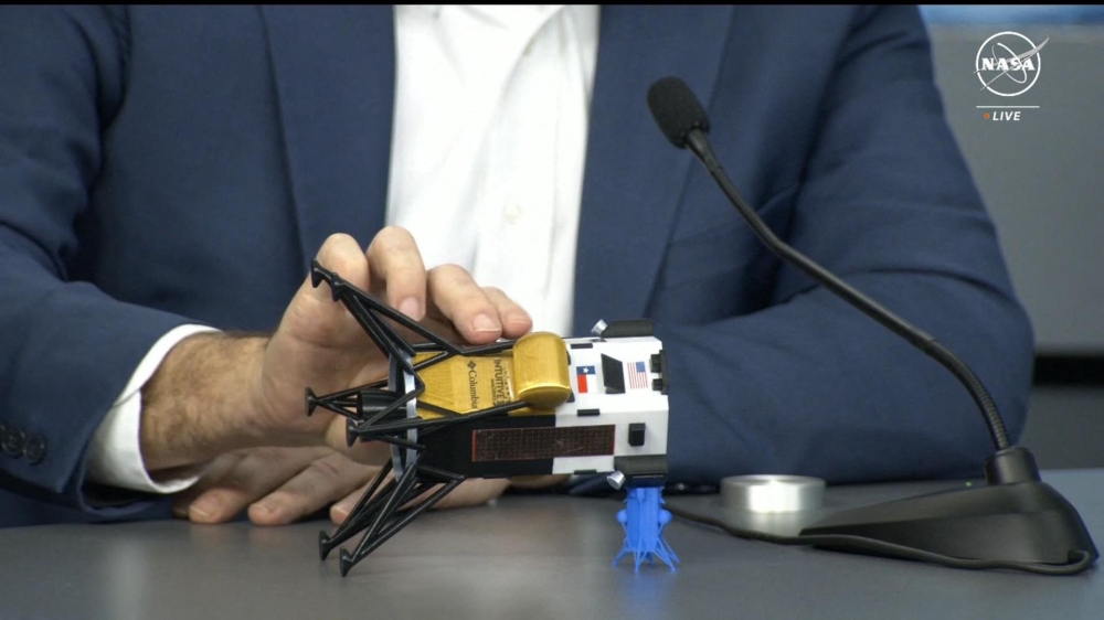 This frame grab from Nasa, shows Intuitive Machines CEO Steve Altemus holding a model of Odysseus to show its position on the side during a press conference at Johnson Space Center in Houstom, Texas on February 23, 2024. (Photo by Handout / NASA TV / AFP)