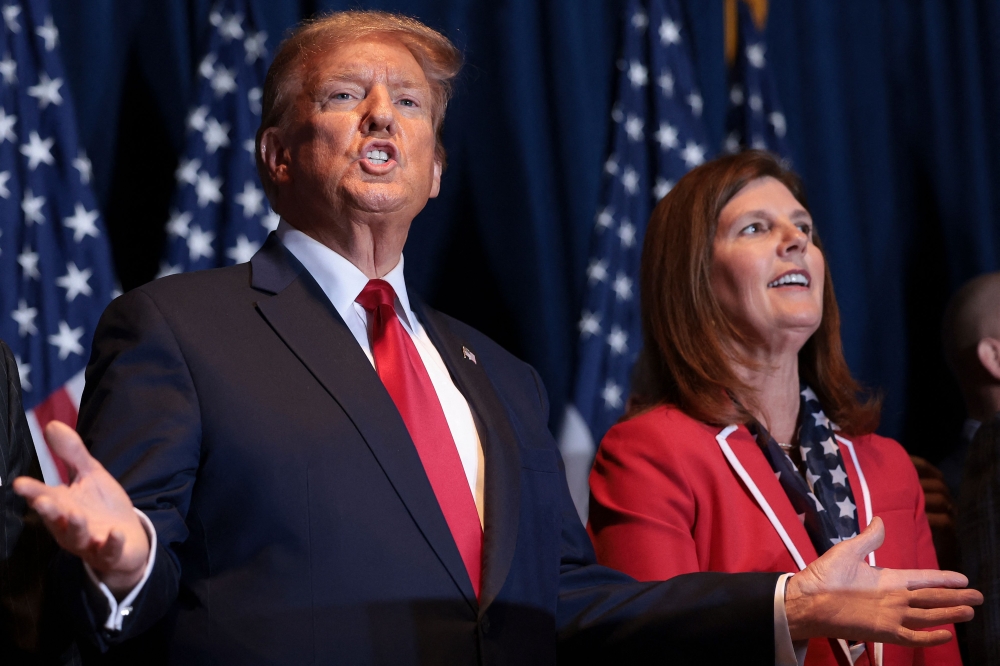 Republican presidential candidate and former President Donald Trump gestures to supporters at an election night watch party at the State Fairgrounds on February 24, 2024 in Columbia, South Carolina. Also pictured is South Carolina Lieutenant Governor Pamela Evette (R). Win McNamee/Getty Images/AFP 