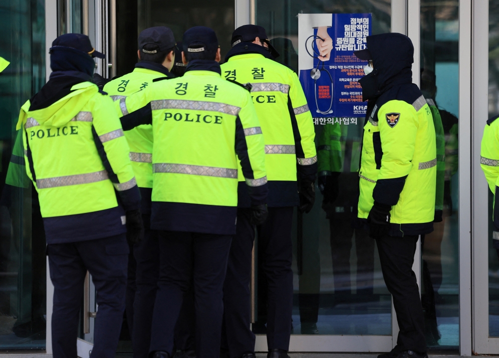Police stand guard in front of the main gate of the Korean Medical Association (KMA) in Seoul on March 1, 2024 as police raid its offices. Photo by YONHAP / AFP