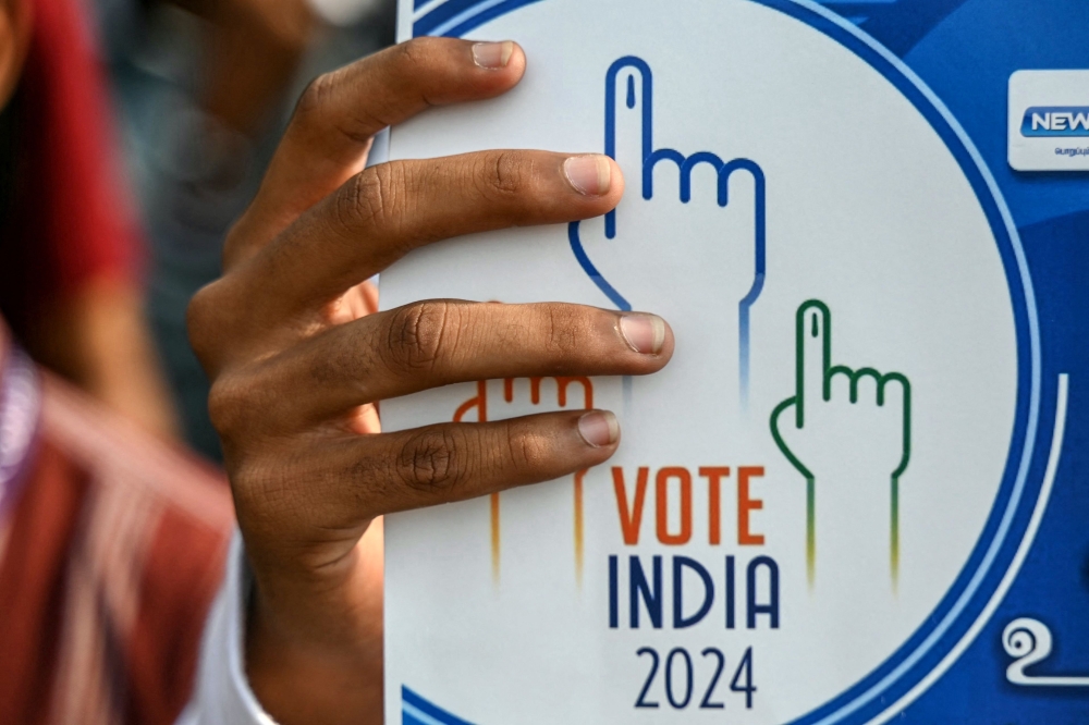 A student holds a placard during a rally to create awareness about the importance of voting ahead of the upcoming general elections, in Chennai on March 9, 2024. (Photo by R.Satish Babu / AFP)
