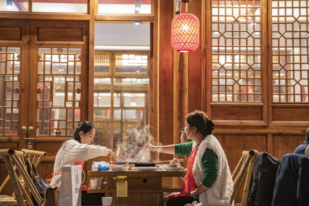 Tourists eat Chongqing hotpot at a traditional scenic area in Yuzhong District in southwest China's Chongqing Municipality, Feb. 10, 2023. Xinhua/Huang Wei
