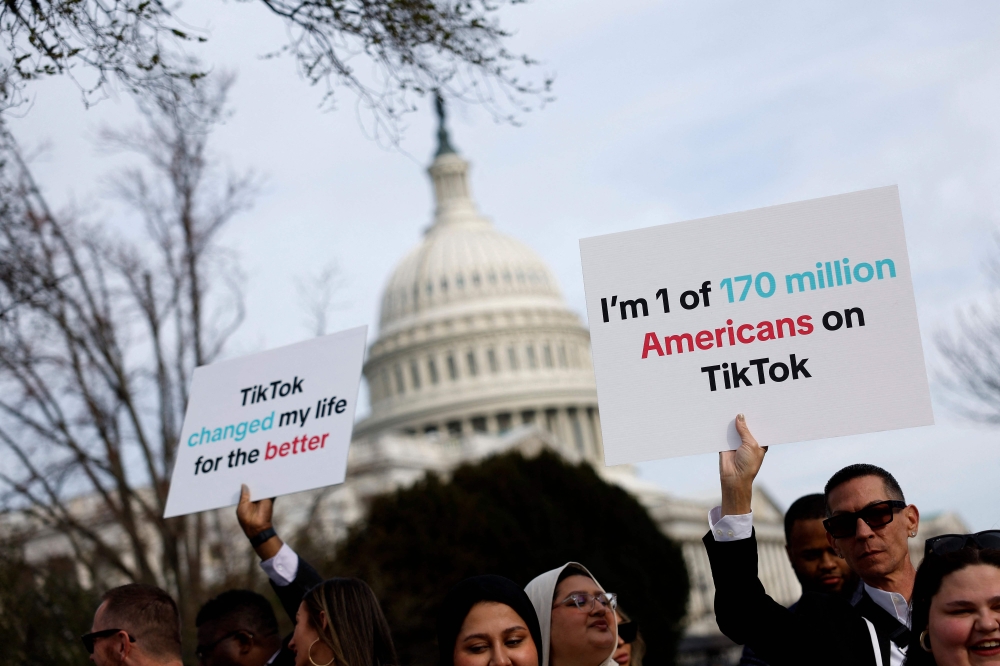 Participants hold signs in support of TikTok outside the U.S. Capitol Building on March 13, 2024 in Washington, DC. (Photo by Anna Moneymaker / GETTY IMAGES NORTH AMERICA / Getty Images via AFP)
