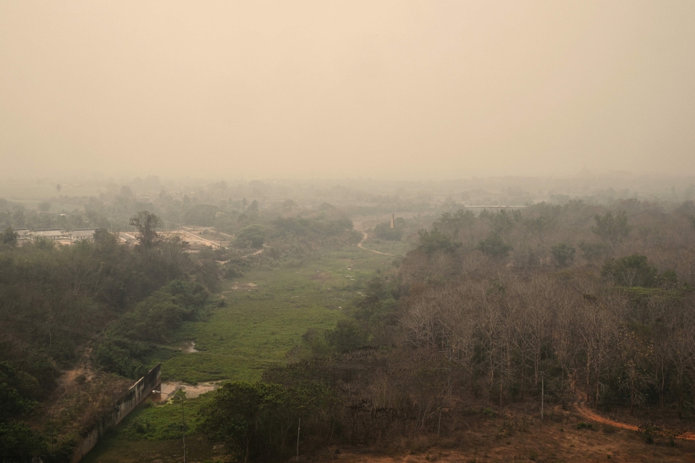 Heavy air pollution is seen over Mae Ngat Somboon Chon Dam in the northern Thai province of Chiang Mai on March 16, 2024. (Photo by Lillian SUWANRUMPHA / AFP)