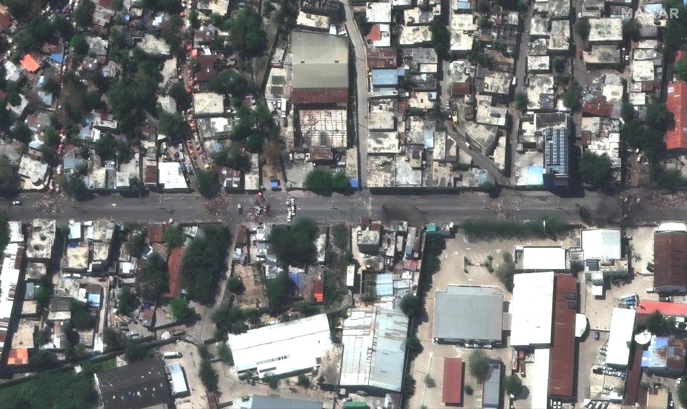 This handout pictures courtesy of Maxar Technologies taken on March 14, 2024 shows roadblocks and burning debris in Delmas street in Port-au-Prince. (Photo by Satellite image 2024 Maxar Technologies / AFP)