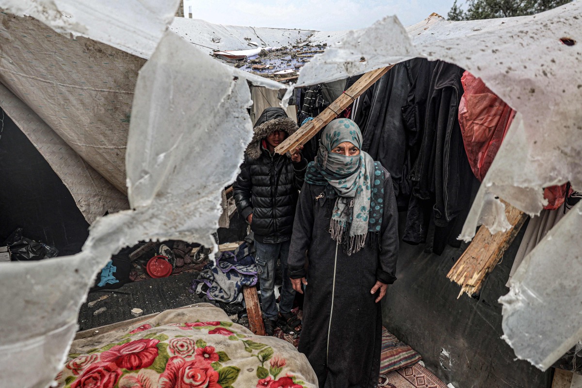 Displaced Palestinians inspect the damage to their tents following overnight Israeli bombardment at the Rafah refugee camp in the southern gaza Strip on March 19, 2024. (Photo by SAID KHATIB / AFP)
