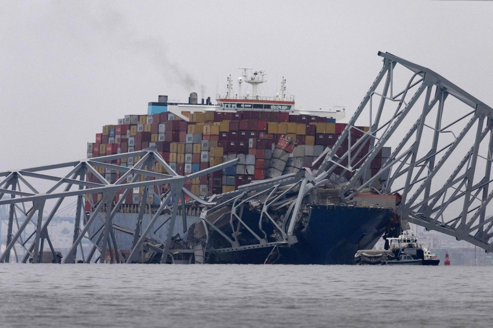 Workers continue to investigate and search for victims at the scene after the cargo ship Dali collided with the Francis Scott Key Bridge yesterday causing it to collapse, on March 27, 2024 in Baltimore, Maryland. Photo by SCOTT OLSON / GETTY IMAGES NORTH AMERICA / Getty Images via AFP