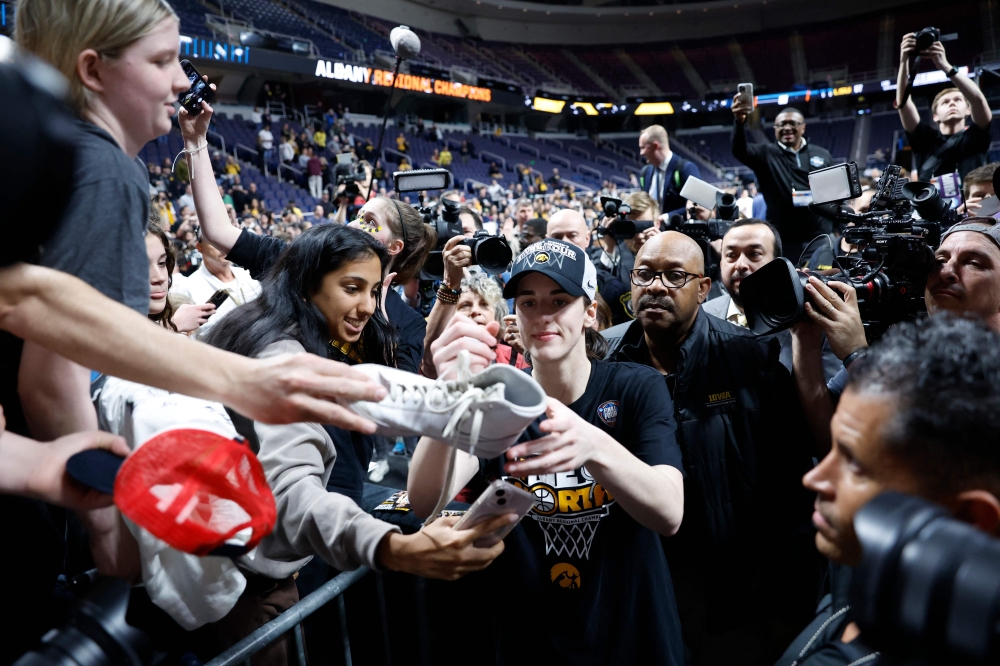 Caitlin Clark #22 of the Iowa Hawkeyes signs autographs after beating the LSU Tigers 94-87 in the Elite 8 round of the NCAA Women's Basketball Tournament at MVP Arena on April 01, 2024 in Albany, New York. (Photo by Sarah Stier / GETTY IMAGES NORTH AMERICA / Getty Images via AFP)

