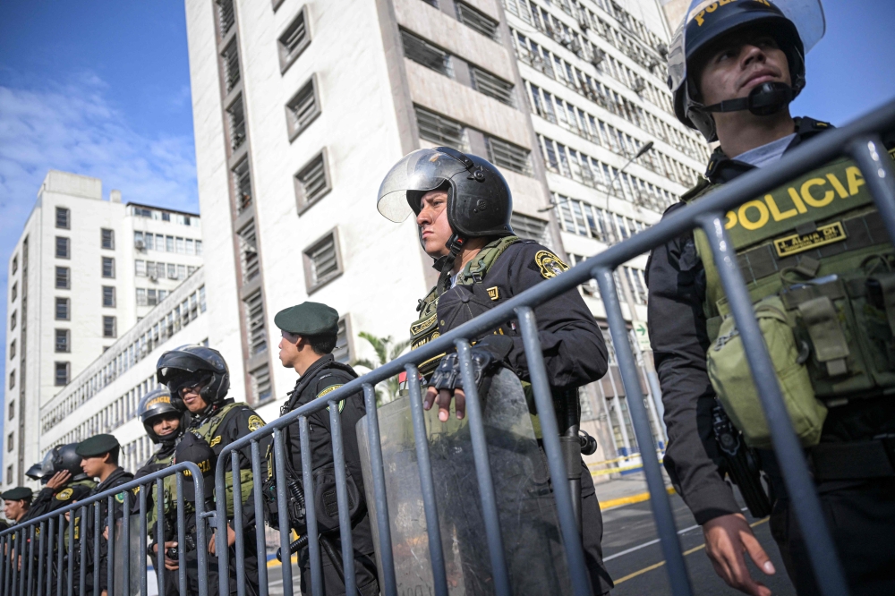 Police officers stand guard outside the Peruvian Prosecutor's building in Lima on April 5, 2024, before the arrival of President Dina Boluarte, summoned by prosecutors amid a scandal over her luxury Rolex and jewelry collection. (Photo by Ernesto BENAVIDES / AFP)
