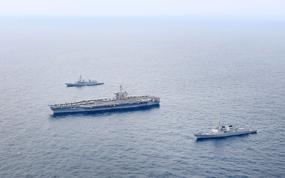This handout photo taken on April 11, 2024 and provided by the South Korean Defence Ministry shows the US Navy's USS Theodore Roosevelt aircraft carrier (C), South Korean Navy's destroyer ROKS Seoae Ryu Seong-ryong (bottom) and Japanese Maritime Self-Defense Force destroyer JS Ariake (top) sailing in formation during a joint maritime drill in international waters south of the southern Jeju island. (Photo by Handout / South Korean Defence Ministry / AFP)