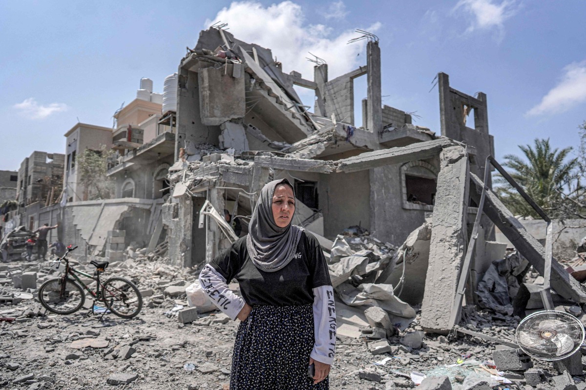 A woman reacts as she stands amidst rubble before a collapsed building in the eastern side of the Maghazi camp for Palestinian refugees in the central gaza Strip on April 15, 2024. (Photo by AFP)