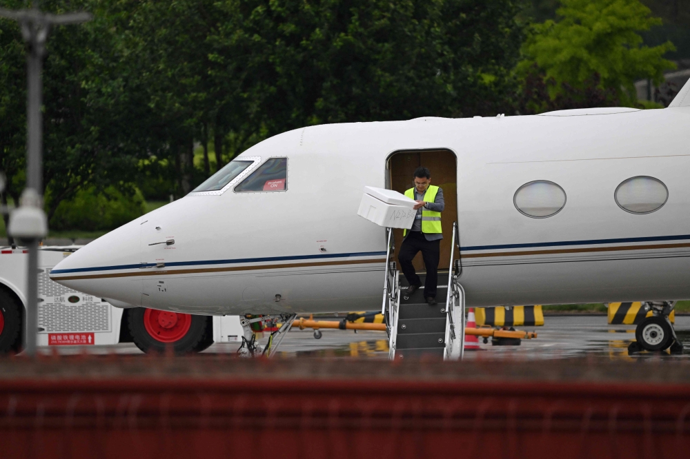 A worker unloads a box from Tesla CEO Elon Musk痴 plane before he boards it to take off from Beijing Capital International Airport, in Beijing on April 29, 2024