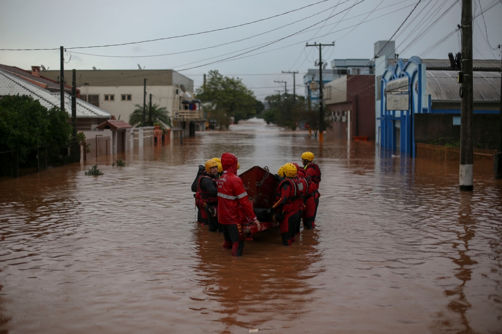 A team of firefighters work at a flooded street in the city center of Sao Sebastiao do Cai, Rio Grande do Sul state, Brazil on May 2, 2024. Photo by Anselmo Cunha / AFP