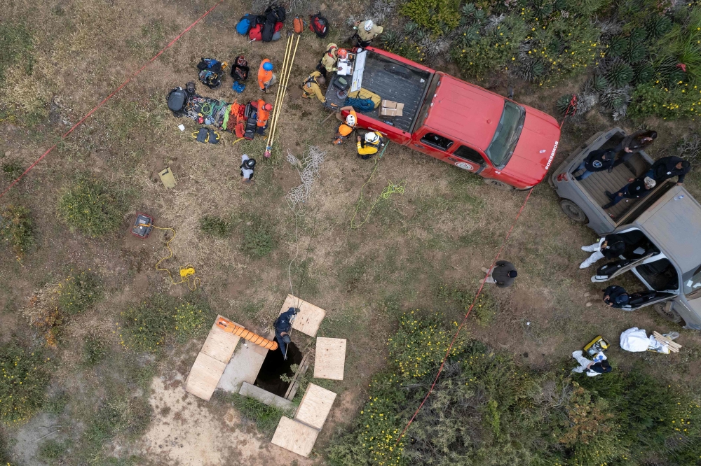 Aerial view showing rescue workers, forensics, and prosecutors preparing to enter a waterhole where human remains were found near La Bocana Beach, Santo Tomas delegation in Ensenada, Baja California State, Mexico, on May 3, 2024. (Photo by Guillermo Arias / AFP)
