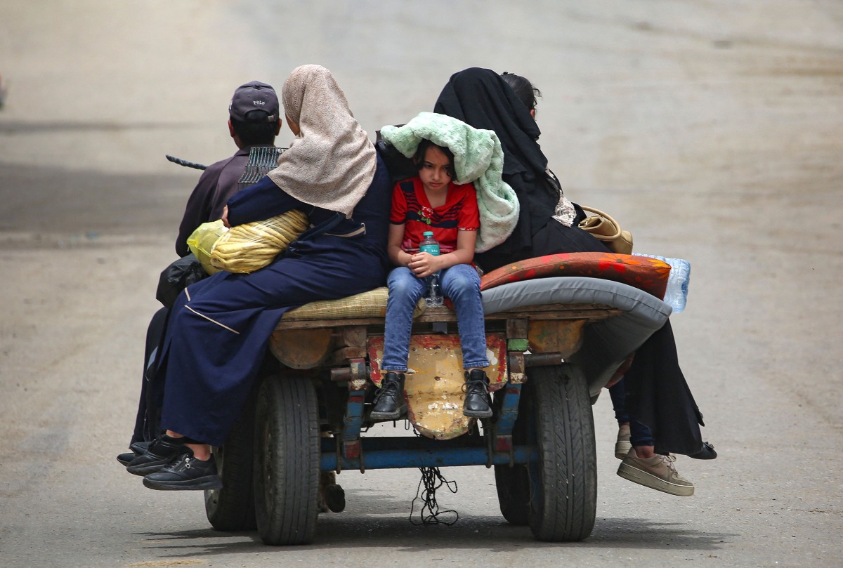 Palestinians sit on an animal pulled cart as they move to safer areas in rafah, in the southern Gaza Strip. (Photo by AFP)