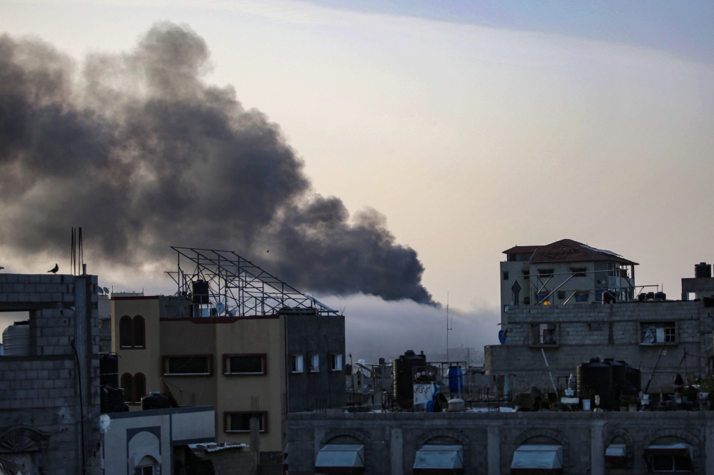 Smoke rises above building at sunrise, in the aftermath of Israeli bombardment in Rafah in the southern Gaza Strip on May 10, 2024. (Photo by AFP)