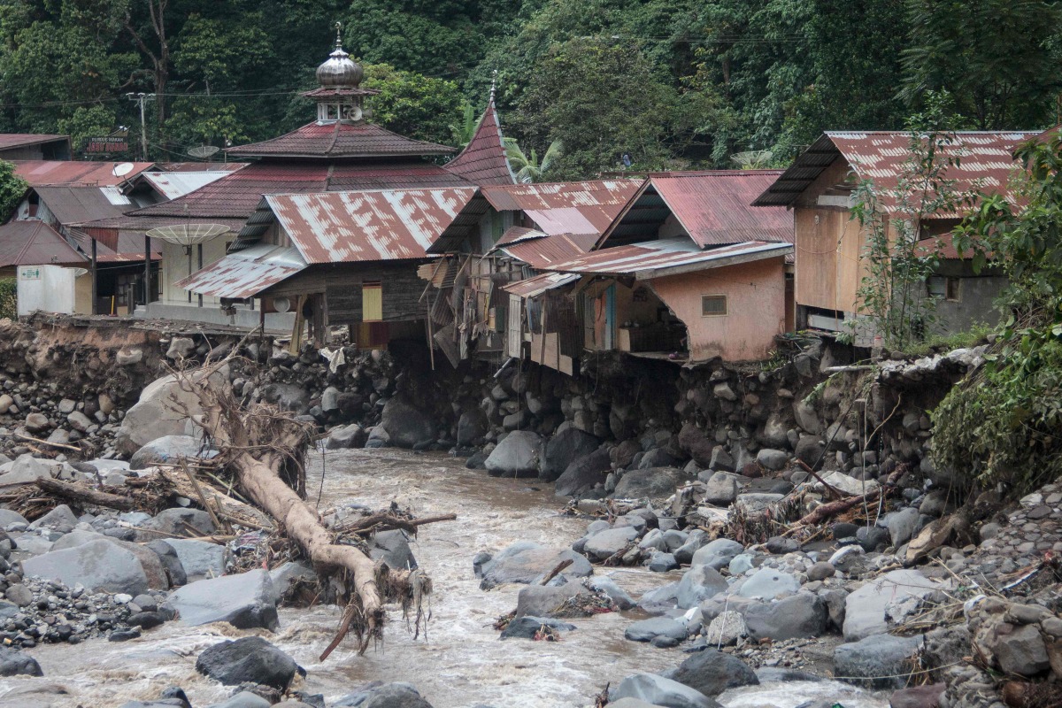 Damaged houses are seen after flash floods and cold lava flow from a volcano in Tanah Datar, West Sumatra, on May 12, 2024.(Photo by REZAN SOLEH / AFP)