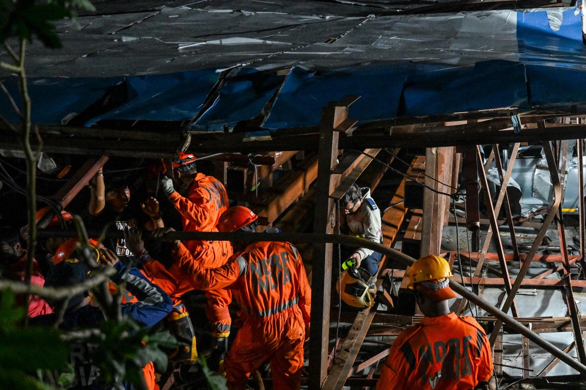 National Disaster Response Force (NDRF) personnel look for survivors during a rescue operation at the site where an advertisement hoarding collapsed on a fuel station after a dust storm in Mumbai on May 13, 2024. (Photo by Punit PARANJPE / AFP)