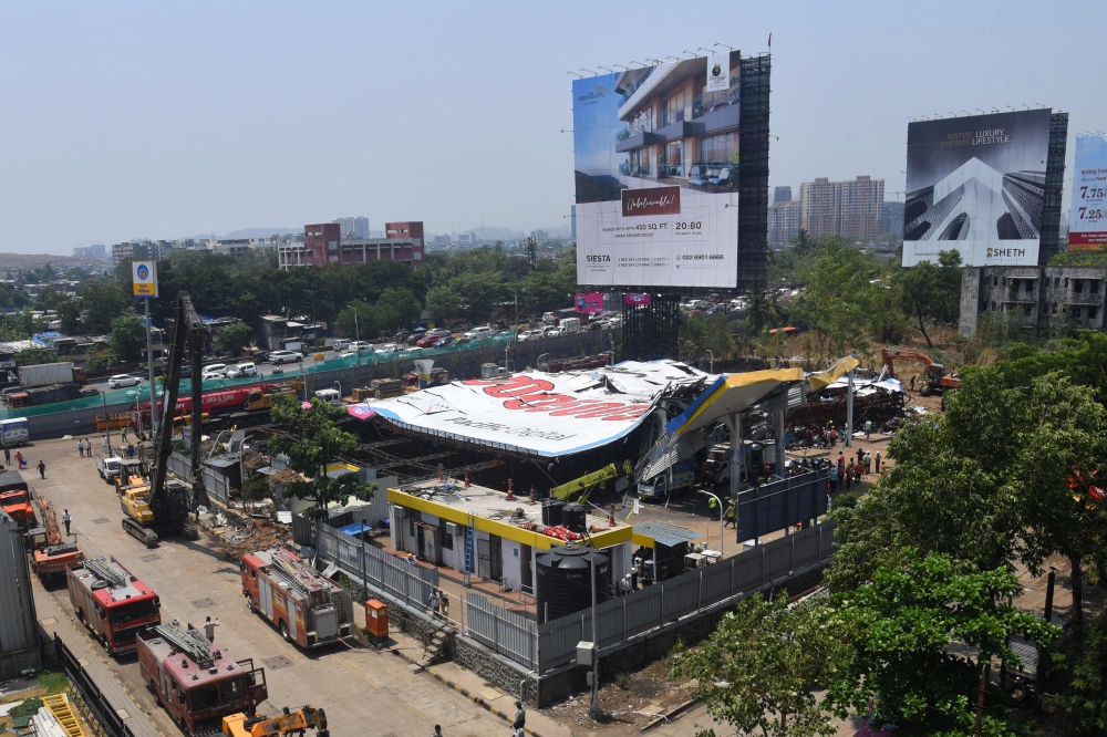 Emergency vehicles are seen parked at the site a day after an advertisement billboard collapsed over a petrol station following a storm, in Mumbai on May 14, 2024. (Photo by Imtiyaz Shaikh / AFP)