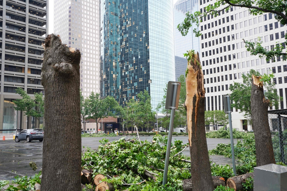 Trees snapped by the storm are chopped up in Houston, Texas, on May 17, 2024, one day after the National Weather Service warned of 