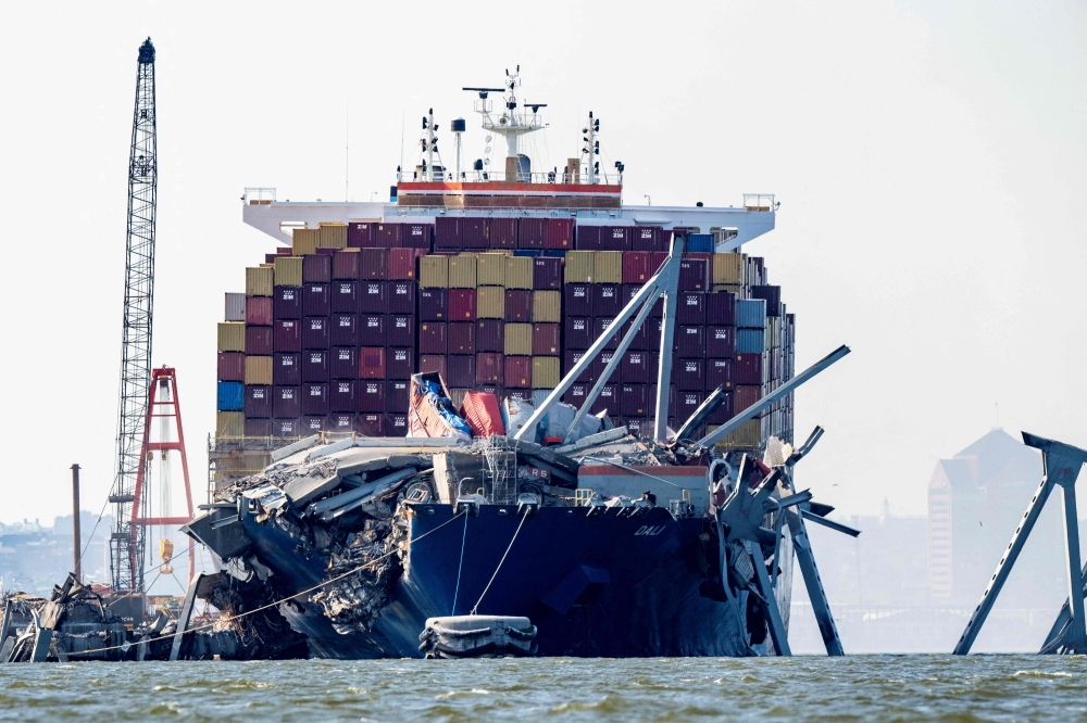A section of the Francis Scott Key Bridge rests in the water next to the Dali container ship in Baltimore on May 13, 2024 after crews conducted a controlled demolition. Photo by ROBERTO SCHMIDT / AFP