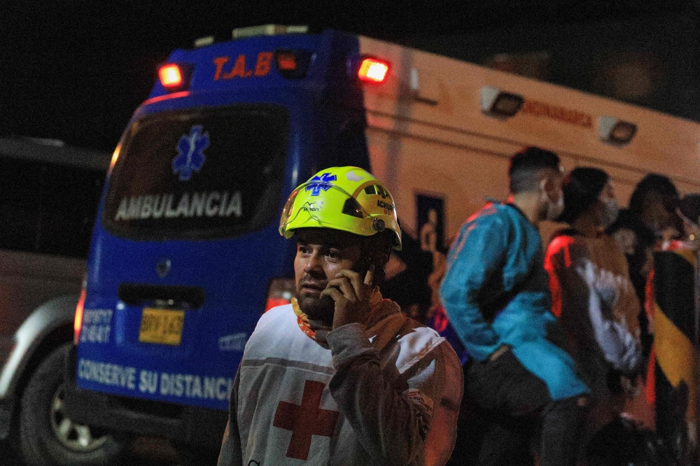 A member of the Red Cross works at the scene of an explosion at a gunpowder factory in Soacha, south of Bogota, on May 22, 2024. Photo by Andrea ARIZA / AFP