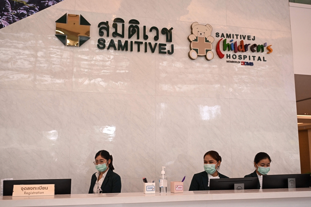 Receptionists stand behind a counter at Samitivej hospital, where some people injured when the Singapore Airlines flight SQ321 suffered severe turbulence mid-flight are receiving medical treatment, in Bangkok on May 23, 2024. Photo by Lillian SUWANRUMPHA / AFP