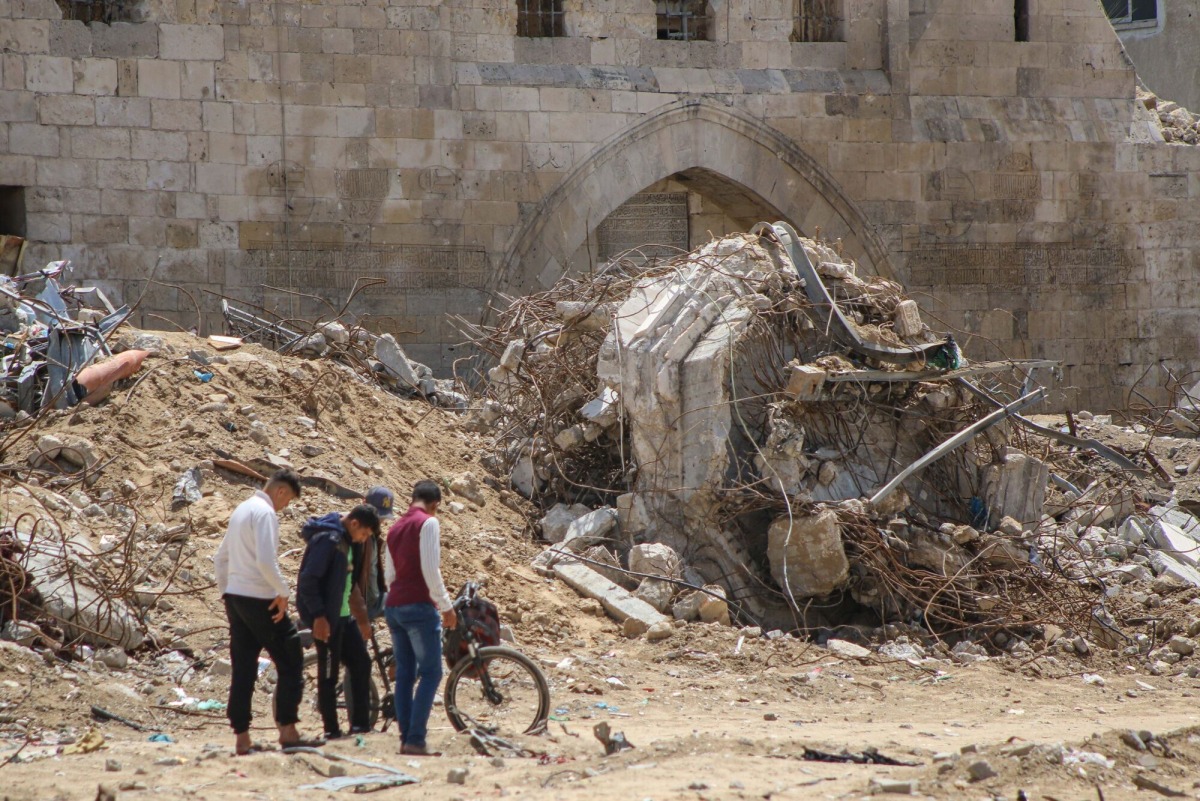 Palestinians near the ruins of destroyed buildings following the withdrawal of Israeli troops in Khan Younis, southern gaza, on April 10. MUST CREDIT: Ahmad Salem/Bloomberg
