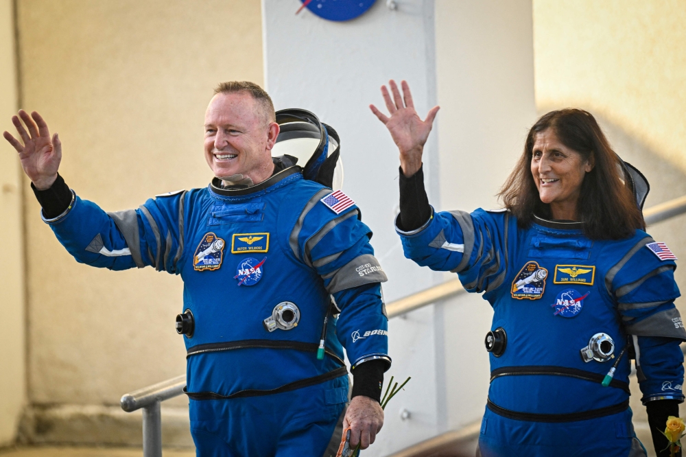 NASA astronauts Butch Wilmore (L) and Suni Williams, wearing Boeing spacesuits, wave as they prepare to depart the Neil A. Armstrong Operations and Checkout Building at Kennedy Space Center for Launch Complex 41 at Cape Canaveral Space Force Station in Florida to board the Boeing CST-100 Starliner spacecraft for the Crew Flight Test launch , on June 5, 2024. Photo by Miguel J. Rodriguez Carrillo / AFP.
 
