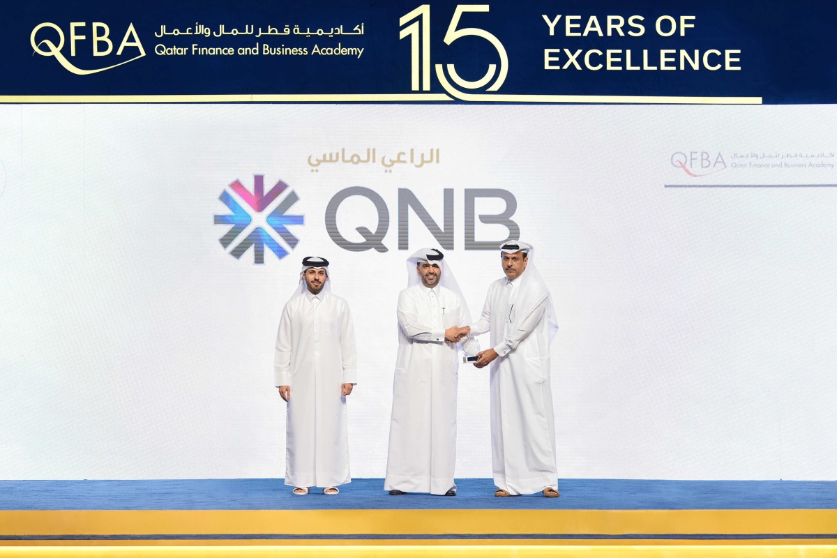 QNB officials with a Qatari graduate during 'Kawader Malia 2024' ceremony.