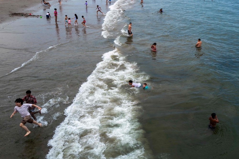 People visit the beach at Coney Island on a sweltering afternoon on the first weekend of summer on June 22, 2024 in the Brooklyn borough of New York City. (Photo by SPENCER PLATT / GETTY IMAGES NORTH AMERICA / Getty Images via AFP)
