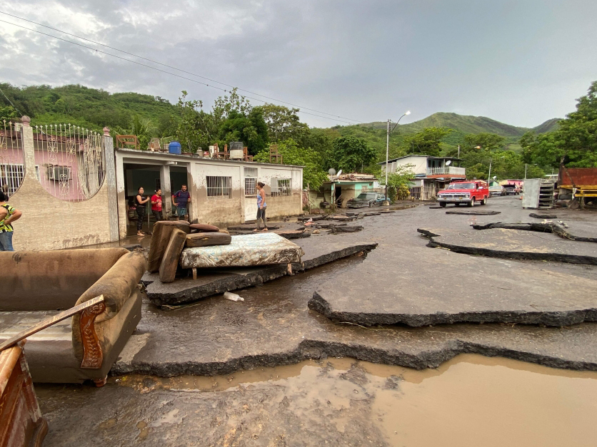 Residents try to recover their belongings from their flooded houses in Sucre State, Venezuela, on July 2, 2024. (Photo by Victor Gonzalez / AFP)